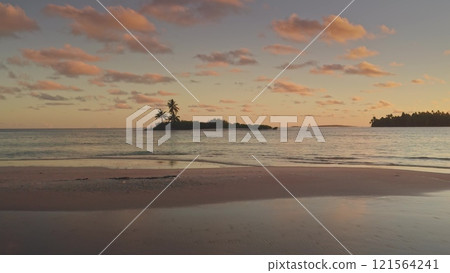 Breathtaking aerial flight over Tikehau island at sunset, vibrant pink sky, tranquil turquoise waters, lush palm trees, serene escape in heart of French Polynesia. Remote wild nature exotic paradise 121564241