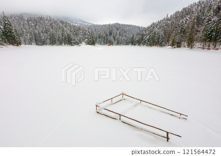 carpathian mountain winter landscape. spruce woods. snow covered frozen lake. scenery in synevyr national park, ukraine. cloudy weather. travel destination background. wintry morning 121564472