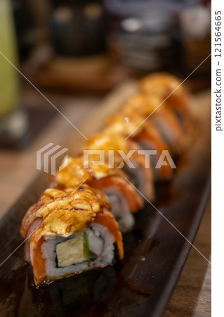 Burned Salmon Sushi roll with cheese served on plate Burned Salmon Sushi roll with cheese served on plate 121564665