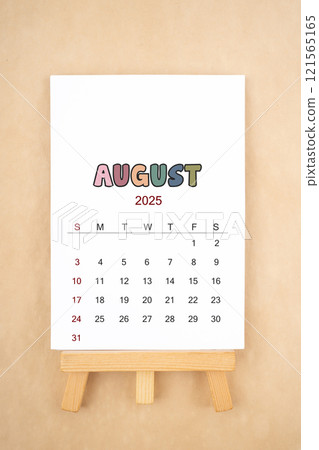 Calendar page for August 2025 with wood easel on old brown background. Calendar page for August 2025 with wood easel on old brown background. 121565165