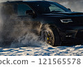 extreme driving, the car is moving rapidly over the smooth snow and creates a spray of snow. 121565578