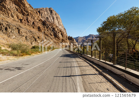 A picturesque road along the border of Armenia and Iran surrounded by mountains and barbed wire 121565679
