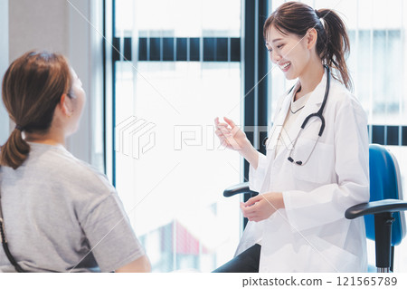 一位年輕女醫生在檢查室與病人交談的圖片 121565789