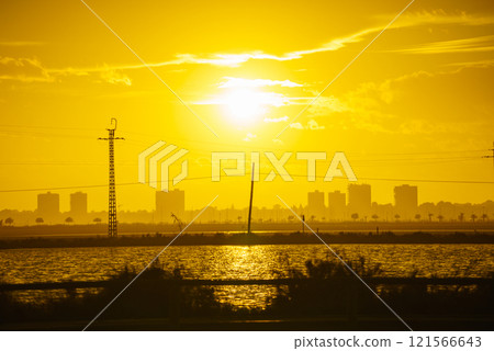 Sunset over sea and urban coastline 121566643