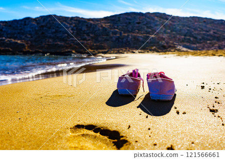 Female sneakers on sand beach 121566661