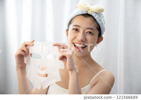 Smiling woman with a face pack 121566689
