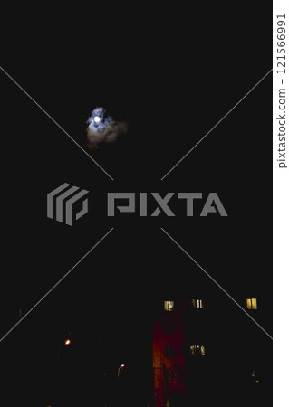 full moon in the night sky above high-rise buildings illuminated by lanterns 121566991