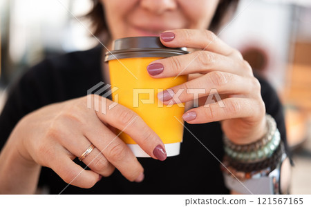 Young Woman Enjoys Hot Tea At Outdoor Cafe 121567165