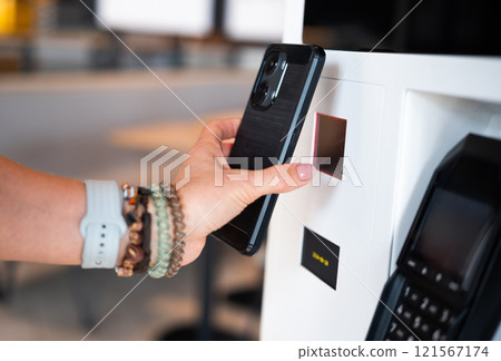 Girl Uses Smartphone To Scan Qr Code At Self-Service Terminal 121567174