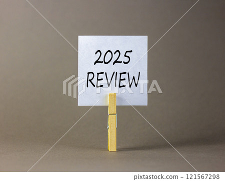 Planning 2025 review new year symbol. Concept words 2025 Review on beautiful white paper on wooden clothespin. Beautiful grey background. Business 2025 review new year concept. Copy space. 121567298