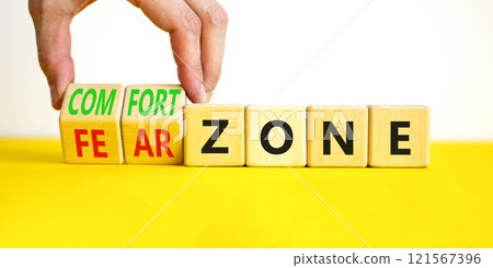 Comfort or fear zone symbol. Concept words Comfort zone Fear zone on wooden cubes. Beautiful yellow table white background. Psychologist hand. Business and comfort or fear zone concept. Copy space. 121567396