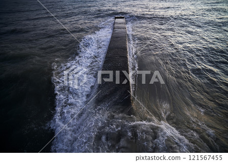 Landscape with a stone pier and raging waves in the sea. 121567455