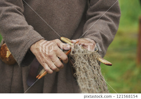 Fisherman weaving a net at a Viking festival in Denmark Fisherman weaving a net at a Viking festival in Denmark 121568154