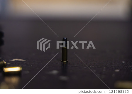 A bullet is sitting on a table 121568525
