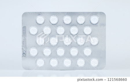 Blister pack containing round white pills displayed on a flat surface 121568660