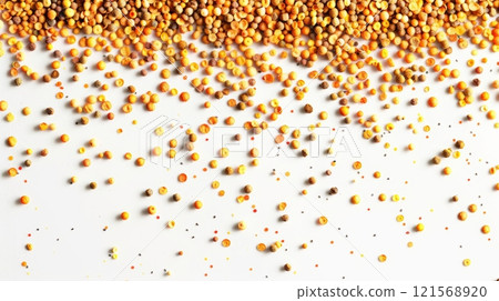 Bee pollen granules spread on a white background. Beekeeping product rich in nutrients. Concept of health supplement, natural apiculture product, and wellness. Banner. Copy space. 121568920