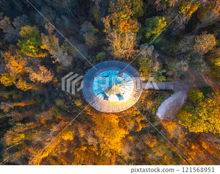 The striking Humprecht chateau rises above Sobotka, surrounded by colorful autumn foliage, illuminated by the warm glow of the sunrise. A peaceful moment in the Bohemian Paradise. 121568951