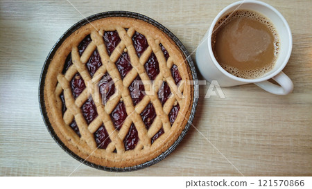 Homemade tart with coffee on wooden table 121570866