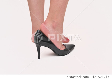 A young woman is trying on black shoes. on a white background A young woman is trying on black shoes. on a white background 121571213