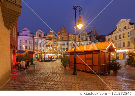 Festive market stalls, Christmas carousel and historic house facades, Poznan, Poland 121572845