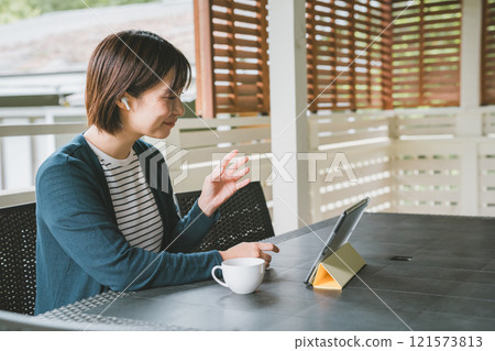 Woman using a tablet on the terrace Woman using a tablet on the terrace 121573813