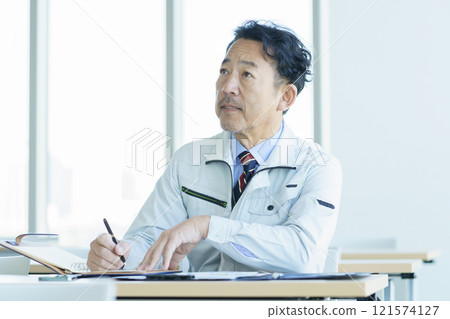 A middle-aged man in work clothes attending a seminar. Photo courtesy of Tokyo Electronics College, Denpa Gakuen Corporation. A middle-aged man in work clothes attending a seminar. Photo courtesy of Tokyo Electronics College, Denpa Gakuen Corporation. 121574127