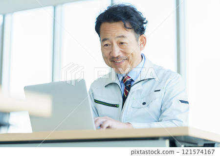 穿著工作服在電腦上工作的中年男子 攝影合作:電波學園教育法人東京電子學校。 穿著工作服在電腦上工作的中年男子 攝影合作:電波學園教育法人東京電子學校。 121574167