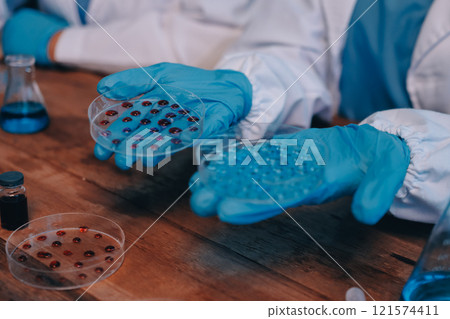 Blood test in the laboratory. Laboratory assistant working with the dispenser. Vacuum tubes with blood. 121574411