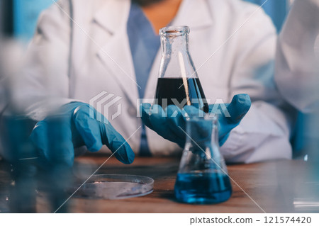 Blood test in the laboratory. Laboratory assistant working with the dispenser. Vacuum tubes with blood. 121574420