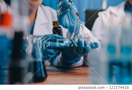 Blood test in the laboratory. Laboratory assistant working with the dispenser. Vacuum tubes with blood. 121574428