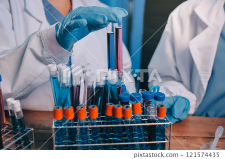 Blood test in the laboratory. Laboratory assistant working with the dispenser. Vacuum tubes with blood. 121574435