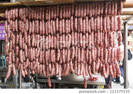 Close-up of ungrilled Taiwanese sausage bunches hanging on wooden sticks. This is one of the street snacks popular among tourists in Taiwan. 121575535