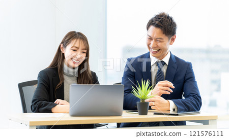 Two businessmen, a man and a woman, having a meeting using a computer 121576111