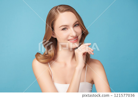 Beautiful young woman with clean fresh skin on blue background, Face care, Facial treatment, Cosmetology, beauty and spa, women portrait. Beautiful young woman with clean fresh skin on blue background, Face care, Facial treatment, Cosmetology, beauty and spa, women portrait. 121577036