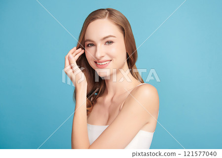 Beautiful young woman with clean fresh skin on blue background, Face care, Facial treatment, Cosmetology, beauty and spa, women portrait. Beautiful young woman with clean fresh skin on blue background, Face care, Facial treatment, Cosmetology, beauty and spa, women portrait. 121577040