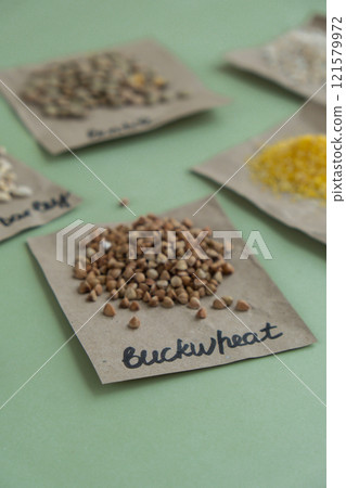 Raw buckwheat porridge with text in paper. Refill product format eco-friendly living. Filling reusable container Whole spelt grain species. High protein fiber-rich vegan plant based food ingredient 121579972