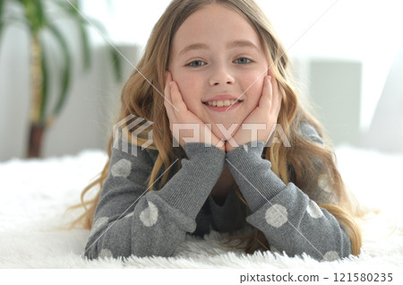 A cute little girl lying on the bed. 121580235