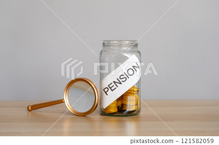 Bank of coins and the inscription Pension. Saving money and retirement concept. Accumulation of pension contributions. Business and finance. Magnifying glass 121582059