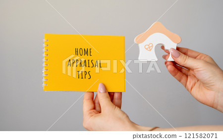 Home Appraisal tips concept. Strategies and best practices homeowners can use to maximize the assessed value of their property during a professional appraisal. Notebook and house in hands 121582071