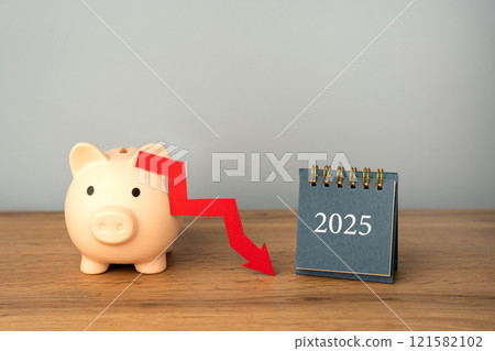 Piggy bank with a downward arrow and a 2025 calendar. Economic crisis and recession. Bankruptcy and financial crisis. Analysis and analytics. Capital outflow. GDP. Forecasting. Piggy bank with a downward arrow and a 2025 calendar. Economic crisis and recession. Bankruptcy and financial crisis. Analysis and analytics. Capital outflow. GDP. Forecasting. 121582102