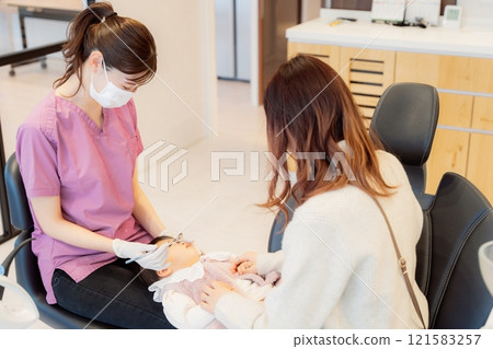 An anxious baby undergoing an infant checkup 121583257