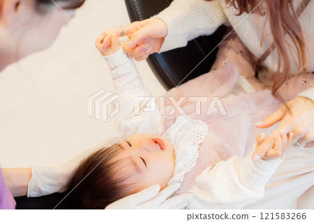 An anxious baby undergoing an infant checkup 121583266