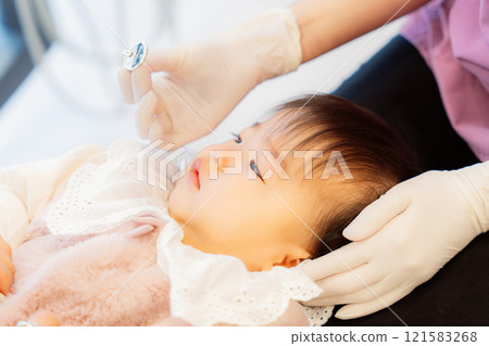 An anxious baby undergoing an infant checkup 121583268