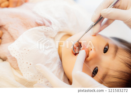 An anxious baby undergoing an infant checkup 121583272