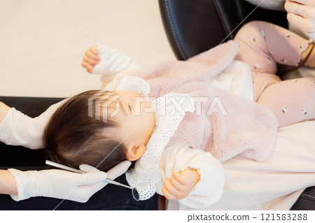 An anxious baby undergoing an infant checkup An anxious baby undergoing an infant checkup 121583288