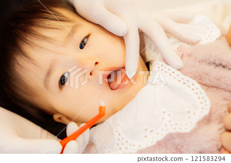 接受嬰兒檢查後一臉焦急的嬰兒 接受嬰兒檢查後一臉焦急的嬰兒 121583294