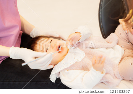 An anxious baby undergoing an infant checkup 121583297