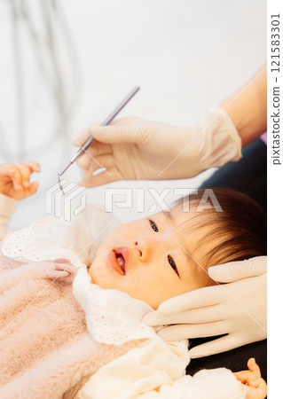 An anxious baby undergoing an infant checkup 121583301