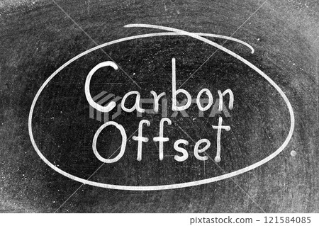 White chalk hand writing in word carbon offset and circle shape on blackboard background 121584085