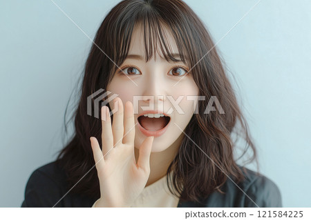 Young Japanese woman screaming loudly with hands over her mouth 121584225